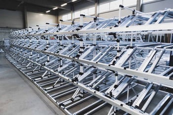 Large flow rack with many channels and roller rails for ergonomic removal and efficient storage 
