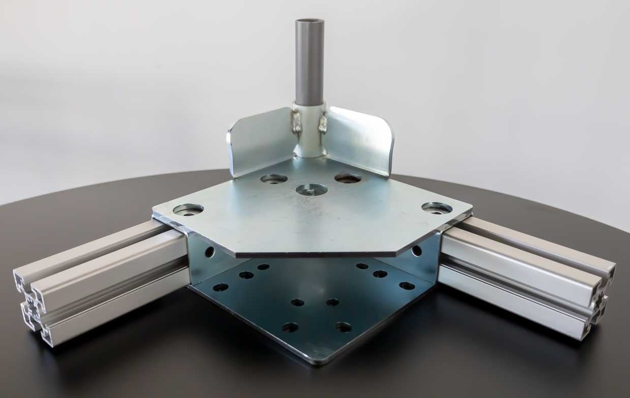 MC steel joint connects two square tubes with one round tube across corner