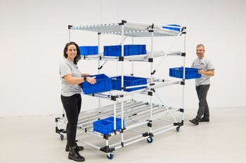 BeeWaTec flow rack made of pipe-racking system is filled with blue load carriers / boxes