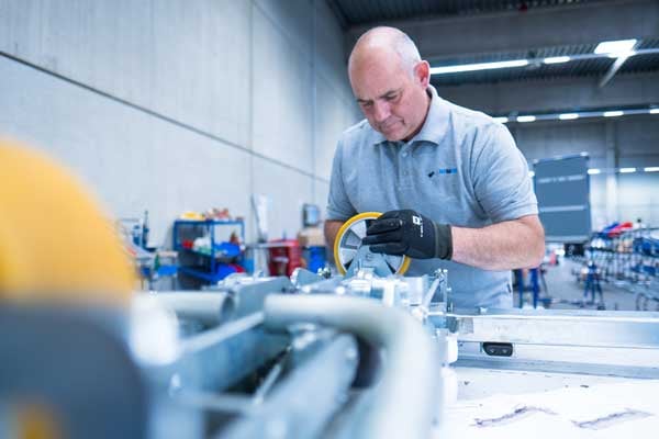 An experienced BeeWaTec employee mounts a wheel on a pipe racking construction as part of a customer order.