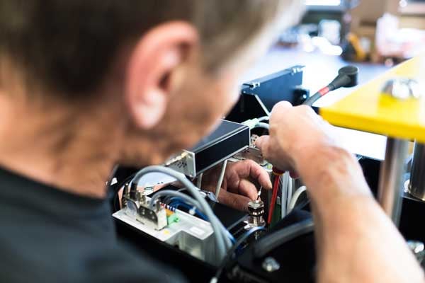 A BeeWaTec electrician carries out professional work on an electrical component.