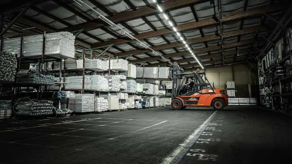 A BeeWaTec employee uses a forklift truck to move pipes.