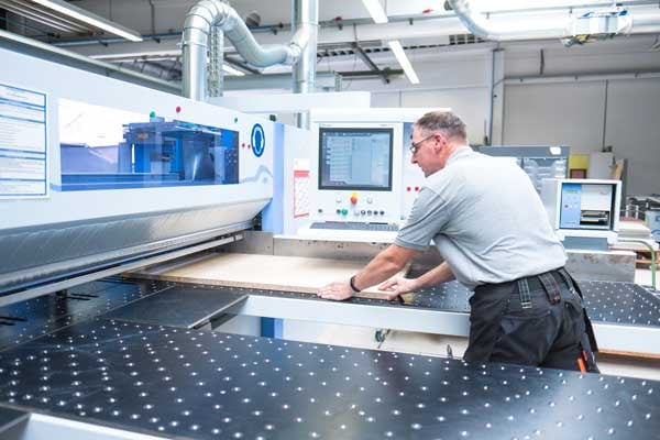 In the in-house carpentry facility, a BeeWaTec employee prepares a wooden panel exactly to size.