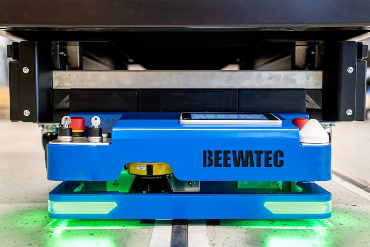 Autonomní mobilní robot od společnosti BeeWaTec přepravuje vozík s materiálem