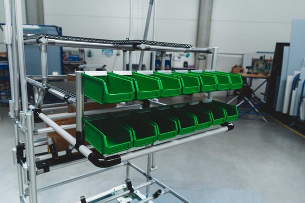 Materialbereitstellung durch grüne Sichtlagerkästen und einem Rohr-Aufbau von BeeWaTec