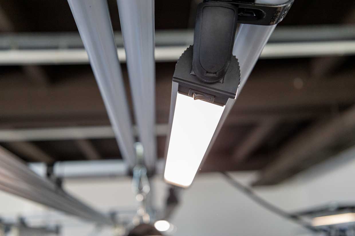 A lamp mounted on a round tube directly above a workstation for ergonomic work. 